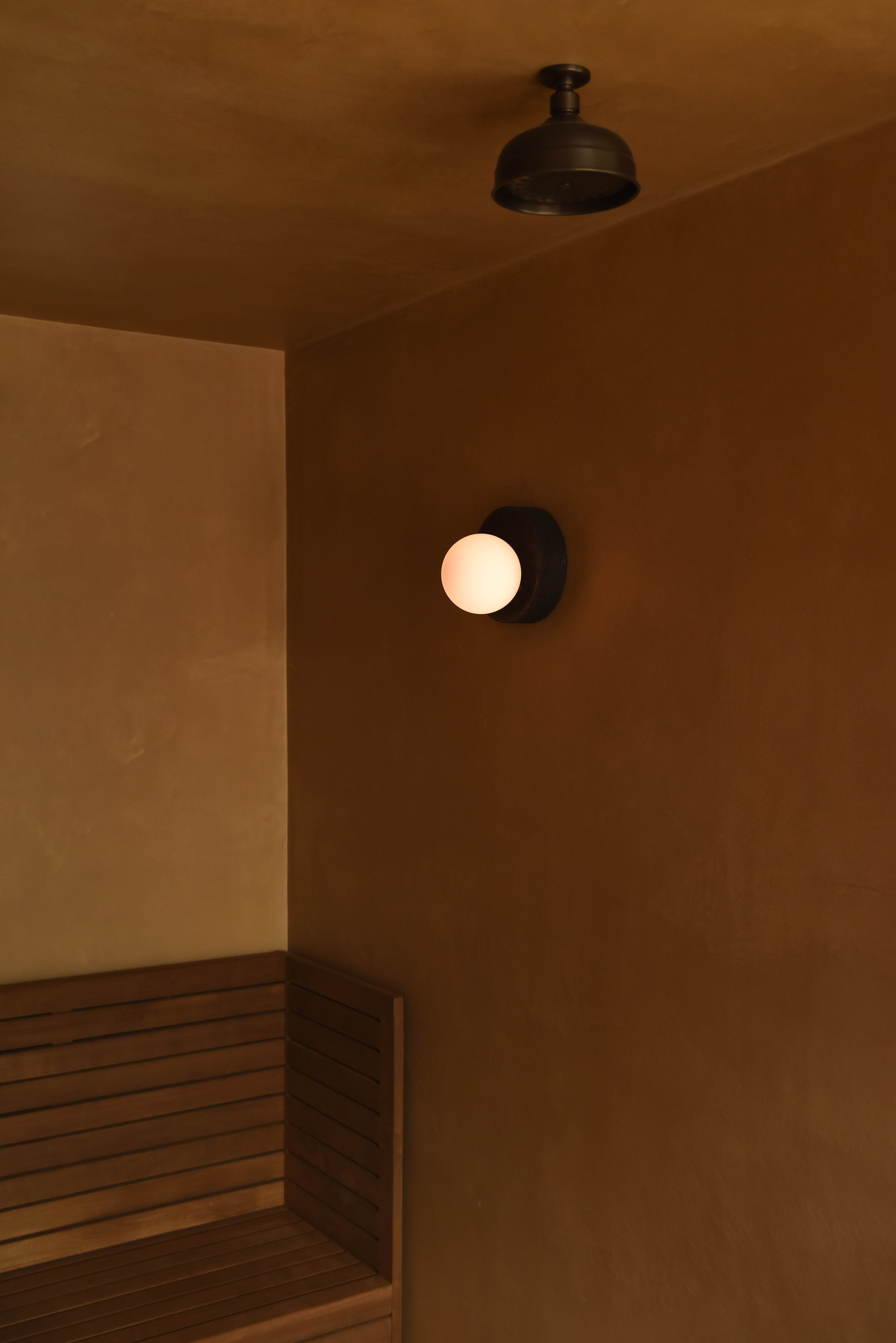 Sauna corner with timber bench and glowing globe light