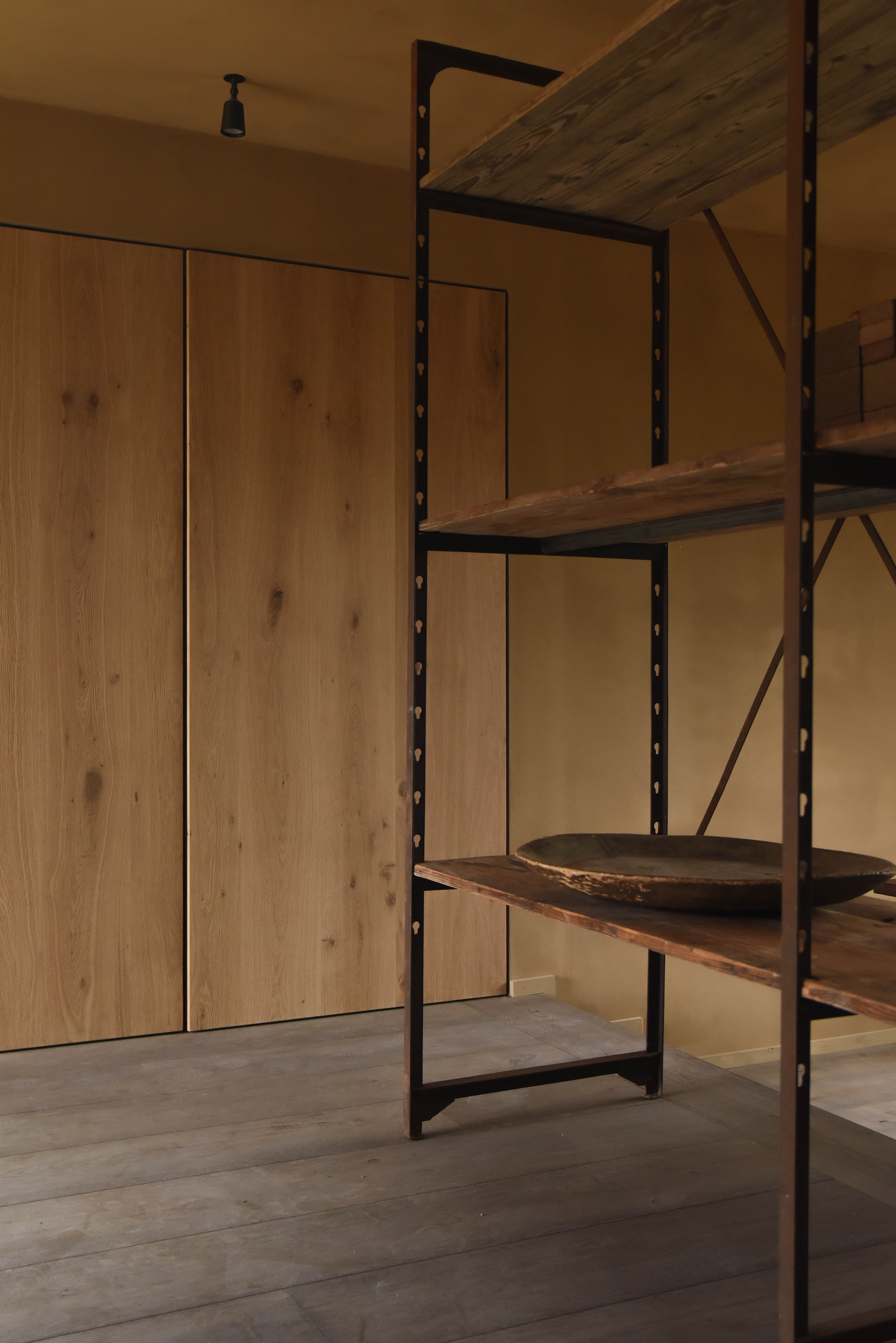 Reclaimed steel and timber shelving against oak cupboards